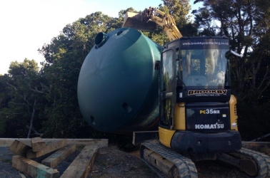 Locating a new water tank after ground preparation.